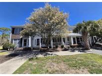 Charming exterior showcasing a townhome with inviting front porch and mature trees on a sunny day at 4115 Little River Rd. # 10-B, Myrtle Beach, SC 29577