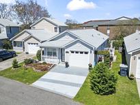 Charming single-story home with a well-manicured lawn, gray siding and an attached one car garage at 413 Chesterfield Ct., Myrtle Beach, SC 29577