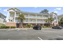Three-story condo building featuring covered balconies, exterior stairs, and parking at 4155 Hibiscus Dr. # 204, Little River, SC 29566