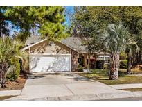 Charming single-story home with a two-car garage and beautifully landscaped front yard featuring palm trees at 4195 Wrens Crossing, Little River, SC 29566
