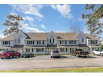 Three-story condo building featuring gray siding and multiple cars in the parking lot in front at 500 Fairway Village Dr. # 5D, Myrtle Beach, SC 29588