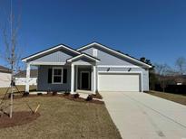 Charming single-story home featuring light blue siding, a two-car garage, and a well-manicured front yard at 5011 Neverland Ct, Myrtle Beach, SC 29588