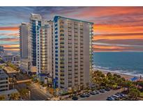 Stunning high-rise condo complex with ocean views and a colorful sunset backdrop at 504 N Ocean Blvd. # 411, Myrtle Beach, SC 29577