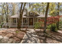 Charming single-story home with a welcoming front porch and beautiful landscaping, surrounded by mature trees at 53 Hope Ln., Pawleys Island, SC 29585