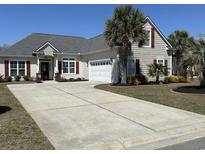Charming home featuring a long driveway, two-car garage, palm trees and complementary dark-red window shutters at 59 Willowbend Dr., Murrells Inlet, SC 29576