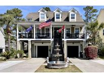 Charming two-story home with a fountain, double garages, and a covered porch adorned with American flags at 817 Falkirk St., Myrtle Beach, SC 29579