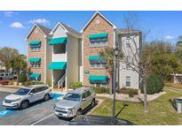Condominium building featuring stone and siding with vibrant green awnings offering covered staircase and designated parking at 9764 Leyland Dr. # 9764 - 5, Myrtle Beach, SC 29572