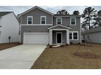 Charming two-story home with gray siding, a two-car garage, and a welcoming front porch at 997 Laconic Dr., Myrtle Beach, SC 29588