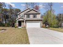 Charming two-story home with stone accents, manicured lawn, and a spacious two car driveway at 1219 Inlet View Dr., North Myrtle Beach, SC 29582