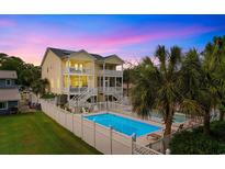 Stunning coastal home featuring a private pool, fenced yard, and multi-level balconies at 213 S Myrtle Dr., Surfside Beach, SC 29575