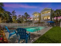 Inviting backyard pool area with chairs and well-maintained landscaping, perfect for outdoor relaxation and entertainment at 213 S Myrtle Dr., Surfside Beach, SC 29575