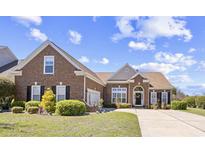 Charming brick home featuring a manicured lawn and inviting curb appeal on a sunny day at 324 Highfield Loop, Myrtle Beach, SC 29579