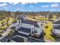 A bird's eye view of a multi-story condo building, overlooking a golf course and scenic landscape at 4827 Orchid Way # 301, Myrtle Beach, SC 29577