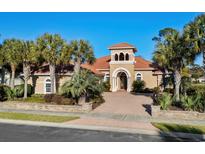 Stunning home boasts a well-manicured lawn, lush landscaping, and a grand entrance with a charming tower feature at 7268 Seville Dr., Myrtle Beach, SC 29572