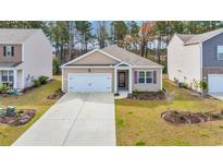 Inviting single-story home featuring a two-car garage and well-manicured lawn at 1016 Laurens Mill Dr., Myrtle Beach, SC 29579