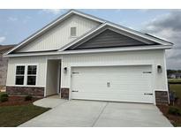Charming single-Gathering home featuring a white garage door and stone accents on the facade at 1025 Jase Dr., Longs, SC 29568