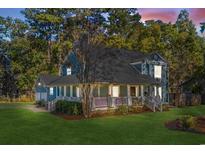 Charming two-story home featuring a covered porch, lush lawn, and mature trees at 160 Shipmaster Ave., Pawleys Island, SC 29585