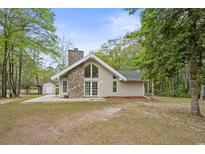 Charming home with stone chimney, large windows, and wooded surroundings at 1047 Holt Rd., Conway, SC 29526
