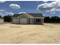 Charming single-story home with a two-car garage, light blue siding, and a well-manicured lawn at 1502 Hardwick Rd., Conway, SC 29526