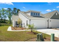 Charming home with a two-car garage, manicured lawn, and a walkway leading to the front door at 216 Kinross Ct., Little River, SC 29566