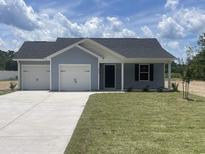 Charming single-story home featuring a two-car garage, well-manicured lawn, and classic curb appeal at 2247 Society Dr., Conway, SC 29527