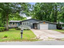 Charming single Gathering home with front porch, garage, blue door, and a well-maintained lawn at 532 Medcalf Dr. Sw, Sunset Beach, NC 28468