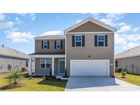Charming two-story home with a two-car garage, a covered front porch, and low-maintenance landscaping at 555 Firouz Dr, Longs, SC 29568