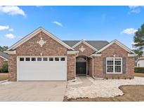 Charming brick home with a two-car garage, black double door entrance, and white rock landscaping at 615 Woodbine Ct., Myrtle Beach, SC 29579