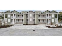 A new two-story townhome with white railings and dual covered decks welcomes you to coastal living at 627 Bonaventure Dr. # 101, Myrtle Beach, SC 29577