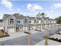 View of newly constructed townhomes showcasing colorful facades, garages and well-manicured landscaping in a friendly community at 904 62Nd Ave. N # A, Myrtle Beach, SC 29572