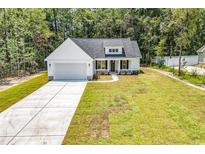 Charming single-story home featuring a well-manicured lawn, attached garage and inviting front porch at 1274 Pinetucky Dr., Galivants Ferry, SC 29544