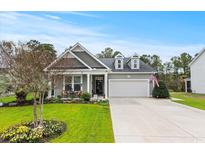 Charming single-story home with beautiful landscaping, a two-car garage, and welcoming curb appeal at 129 Astoria Park Loop, Conway, SC 29526