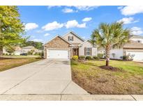 Charming single-story home with stone accents, a well-manicured lawn, and a two-car garage at 1000 Oak Marsh Ln., North Myrtle Beach, SC 29582