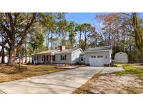 Charming single-story home with a long driveway and a detached two-car garage at 1068 Harbor Dr., Calabash, NC 28467