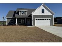 Charming home featuring board and batten siding, a two-car garage, and a well-manicured lawn at 1353 White Oak Ln., Galivants Ferry, SC 29544
