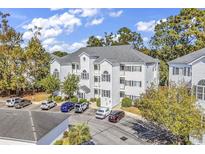 Three-story condominium building featuring classic white facade and ample parking at 1525 Lanterns Rest Rd. # 304, Myrtle Beach, SC 29579