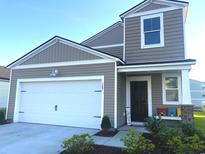 Charming home with a white garage door, neutral siding, and inviting front porch decor at 187 S Reindeer Rd., Surfside Beach, SC 29575