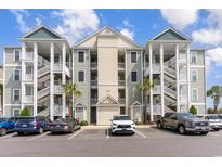 Three-story condo building with outdoor staircases, parking and light green siding at 189 Ella Kinley Circle # 203, Myrtle Beach, SC 29588
