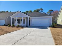 Charming single-story home featuring a covered porch, attached two-car garage, and well-manicured landscaping at 2030 Lone Cypress Dr, Myrtle Beach, SC 29579