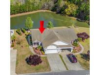 Beautiful home featuring an attached garage, large driveway, pond view and manicured landscaping at 204 Rosewater Loop, Myrtle Beach, SC 29588