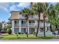 Inviting condo featuring white balconies and stairs accented by mature palm trees and well-maintained landscaping at 211 76Th Ave. N # A-2, Myrtle Beach, SC 29572