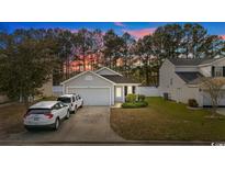 Charming single-story home featuring an attached garage, landscaped yard, and a driveway for two cars at 230 Junco Circle, Longs, SC 29568