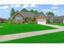 Charming brick home with lush lawn, blue shutters, and attached two-car garage at 3148 Bayhaven Dr., Myrtle Beach, SC 29579