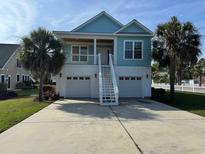 Charming two-story home featuring a spacious driveway, dual garages, and inviting staircase with palm trees at 3851 Journeys End Rd., Murrells Inlet, SC 29576