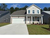 Charming two-story home featuring a two-car garage, neutral siding, and well-manicured landscaping at 393 Sun Colony Blvd., Longs, SC 29568