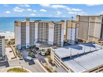 Beautiful aerial view of a light beige beachfront condominium with a parking deck, the beach, and the blue ocean at 4800 S Ocean Blvd. # 1103, North Myrtle Beach, SC 29582