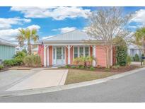 Charming peach home with a metal roof, white trim, American flag and well-manicured landscaping at 5009 Sea Coral Way, North Myrtle Beach, SC 29582