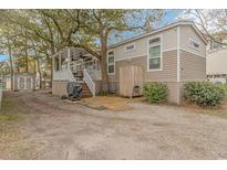 Charming home exterior with an outdoor shower, porch, and storage shed at 6001-Mh26 S Kings Hwy., Myrtle Beach, SC 29575
