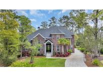 Beautiful brick two-story home featuring professional landscaping and a paved driveway at 653 Whispering Pines Ct., Murrells Inlet, SC 29576