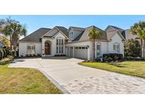 Elegant brick home featuring well-manicured landscaping, a spacious driveway, and a three car garage at 805 East Coast Ln., North Myrtle Beach, SC 29582